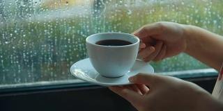 下雨天靠窗喝咖啡的女人