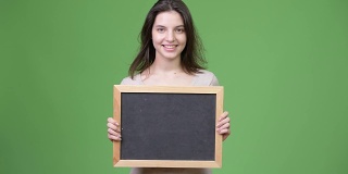 年轻快乐的漂亮女人拿着黑板
