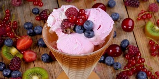 森林水果冰淇淋杯在木桌上旋转