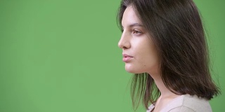 侧面的年轻美丽的女人对绿色的背景