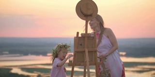 年轻的白人妇女和女儿画自然在夏山日落