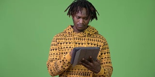 年轻英俊的非洲男子使用数字平板电脑和思考