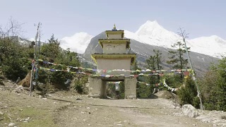 在尼泊尔喜马拉雅山徒步旅行的游客穿过拱门离开村庄。视频素材模板下载