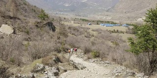 导游带领的游客正在尼泊尔马纳斯鲁地区的喜马拉雅山徒步旅行。