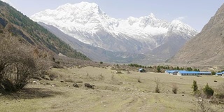 导游带领的游客正在尼泊尔马纳斯鲁地区的喜马拉雅山徒步旅行。