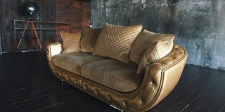 优雅的饱和光泽的金色皮革沙发椅，棕色皮革背景