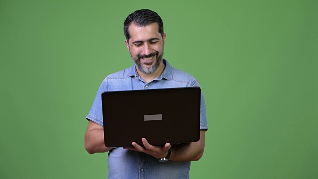 英俊的波斯胡须男子使用笔记本电脑