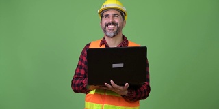 英俊的波斯胡须男建筑工人使用笔记本电脑