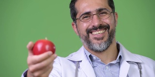 英俊的波斯胡子男子医生作为营养学家给苹果