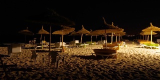 游客们在夜晚的海滩上休息和游泳