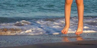 靠近小女孩的腿对一个背景海滨