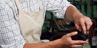 Shoemaker polishing leather shoes with a piece of soft cloth