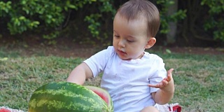 图片中的婴儿正在吃西瓜