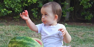 图片中的婴儿正在吃西瓜