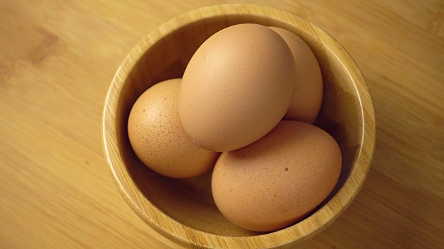 Rotating egg in wooden bowl, 4k