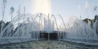 日落时公园里的喷泉。慢动作
