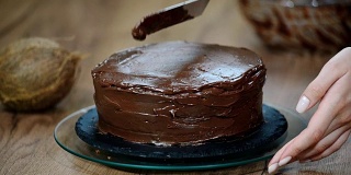 糕点师在蛋糕上涂上巧克力奶油。