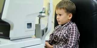 小男孩在现代眼科诊所检查视力。