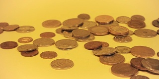 手堆叠不同的硬币在一个彩色的背景