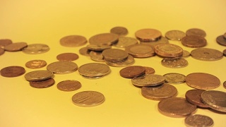 手堆叠不同的硬币在一个彩色的背景视频素材模板下载