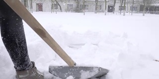寒冷的冬天的早晨，人们在暴风雪期间用手从街上铲雪