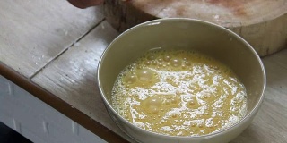 将鸡蛋打在棕色的碗里，准备做煎蛋卷