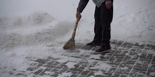 那个不知名的人清扫街上的积雪。缓慢的运动。