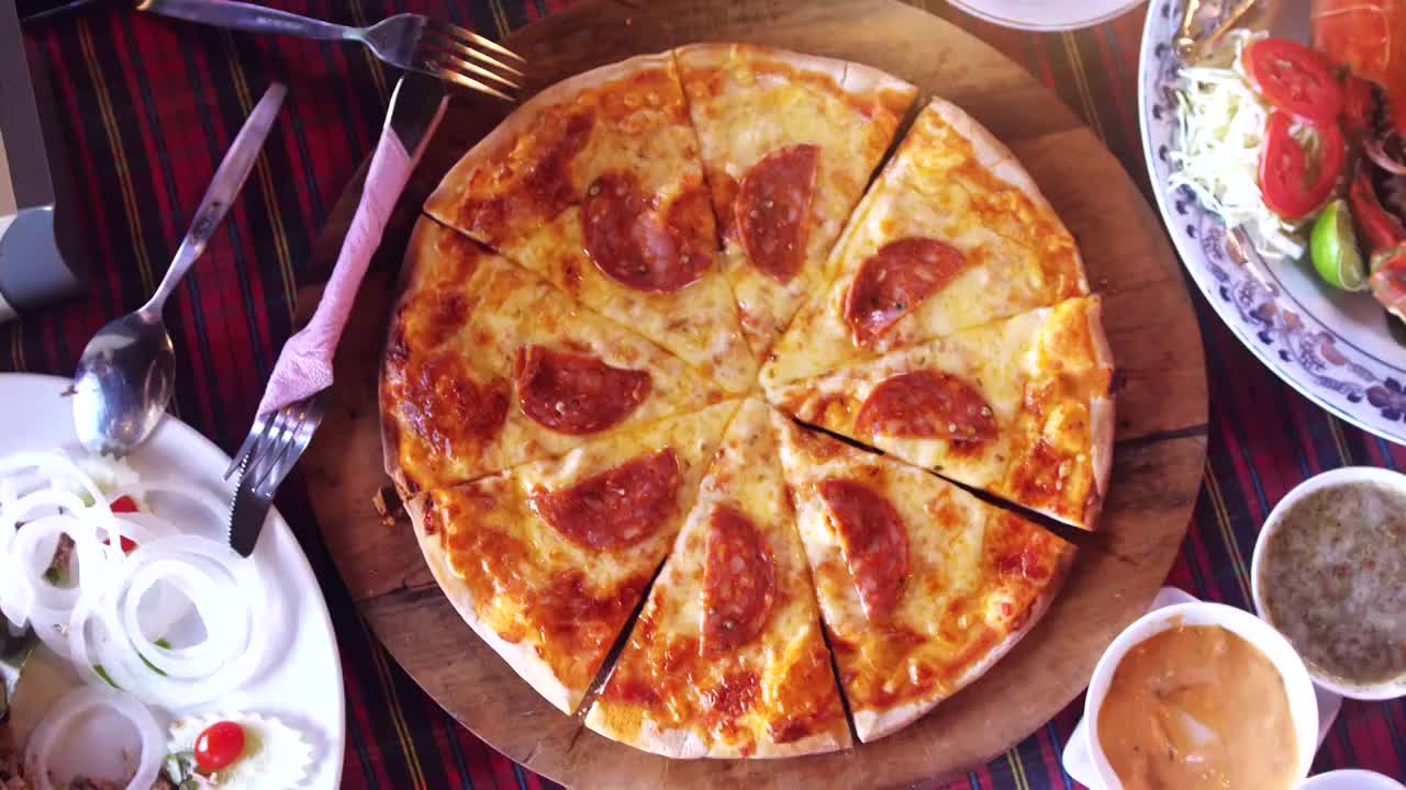 俯视图的一个披萨香肠和蔬菜沙拉，相机旋转。缓慢的运动。3840 x2160