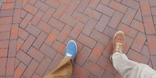 两个人的腿，行走在街道或人行道上