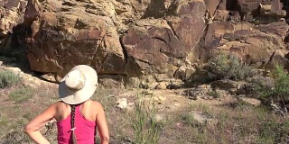 女人探索古老的岩画，怀俄明州传奇的岩石州考古遗址