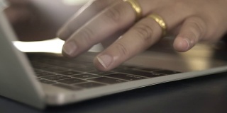 女人在笔记本电脑键盘上打字，特写