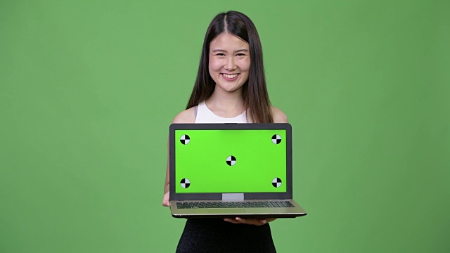 年轻美丽的亚洲女商人展示笔记本电脑