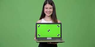 年轻美丽的亚洲女商人展示笔记本电脑