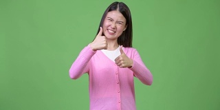 年轻美丽的亚洲女人竖起大拇指