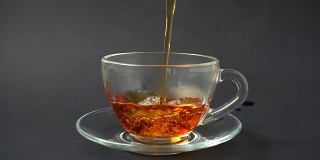 把茶倒进杯子里。缓慢的运动。