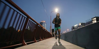 一名男子晚上在城市的桥上慢跑