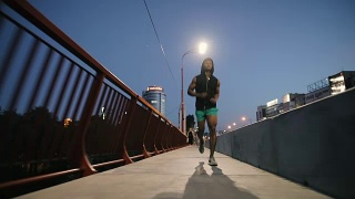 一名男子晚上在城市的桥上慢跑视频素材模板下载
