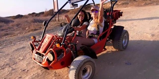 人们在沙丘越野车在沙漠景观。女孩喜欢童车