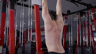 年轻的健身者在健身房用负重器械做运动，健身训练理念视频素材模板下载
