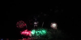 奇妙的多色烟花与烟雾从海上的大船上的夜空背景的4k镜头，庆祝概念