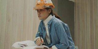 泰国建筑师技术员女子检查她的工作与装修办公室设计项目