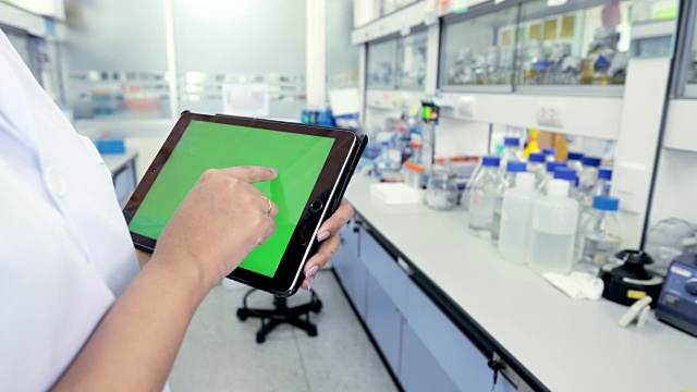 科学家在实验室使用带绿色屏幕的数字平板电脑