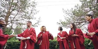 在大学校园里，快乐的毕业生把学位帽抛向空中，大笑着庆祝毕业。教育、成功与现代青年观念。