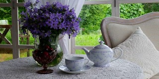 一壶茶和一束蓝色的花。