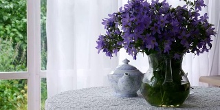 一壶茶和一束蓝色的花。