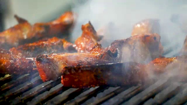 厨师的手是烧烤泰国风格的烧烤木炭和烟在泰国街头食品或夜市，美食和旅游的概念。