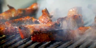 厨师的手是烧烤泰国风格的烧烤木炭和烟在泰国街头食品或夜市，美食和旅游的概念。