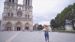 快乐快乐的年轻女子自由奔跑在巴黎巴黎圣母院，法国在慢动作视频素材模板下载