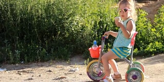 在一个阳光明媚的夏日，骑着自行车的孩子戴着太阳镜吃冰淇淋。