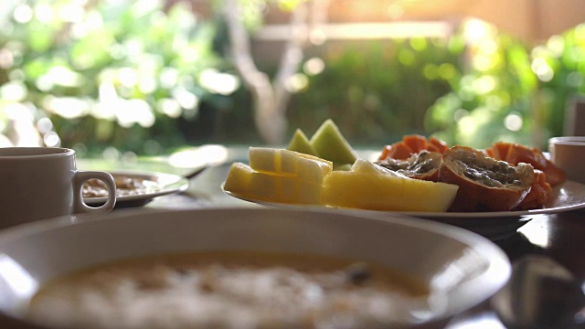 健康美味的早餐，热带水果，燕麦粥和一杯咖啡在假期